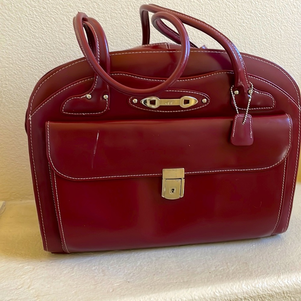 Purse style briefcase. Color maroon. 4 different compartments & laptop sleeve